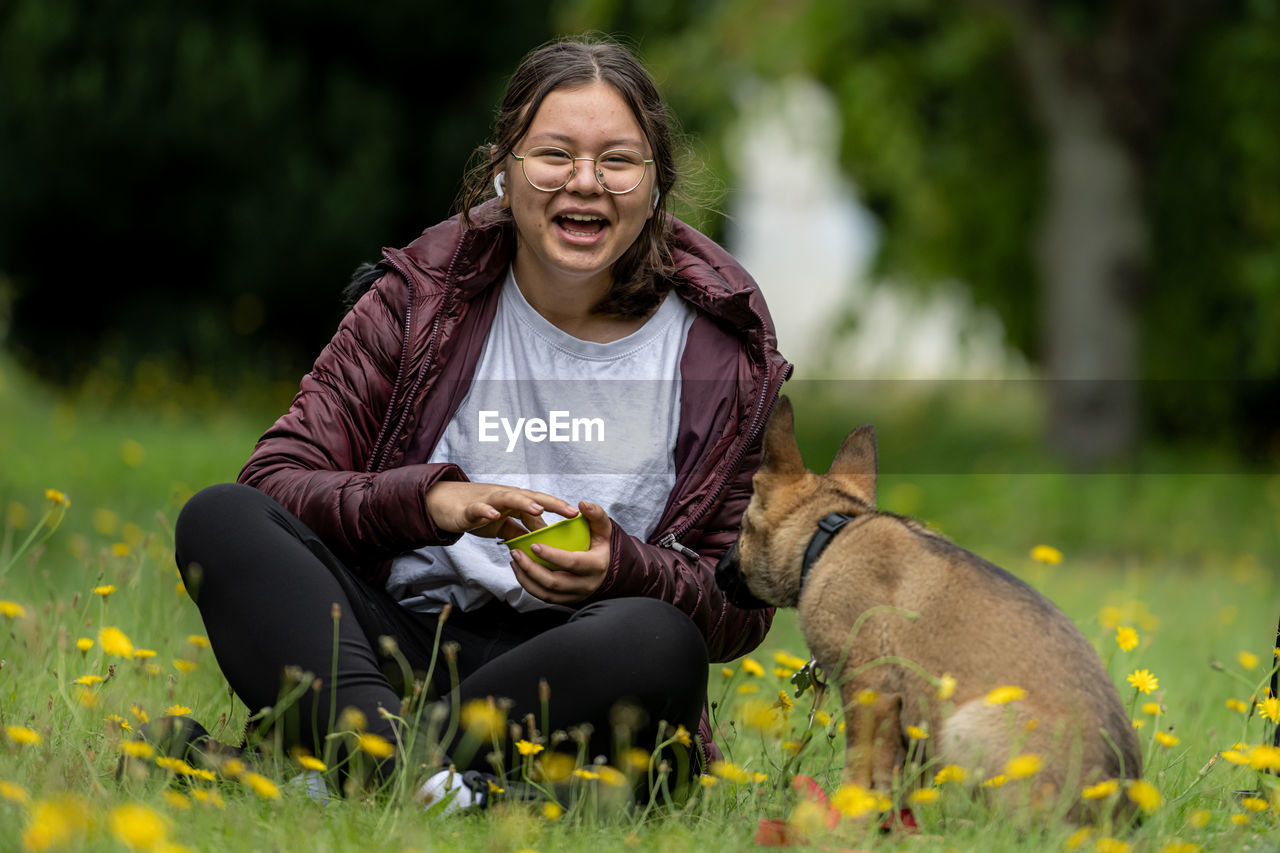 A teenage girl plays with a german shepherd puppy