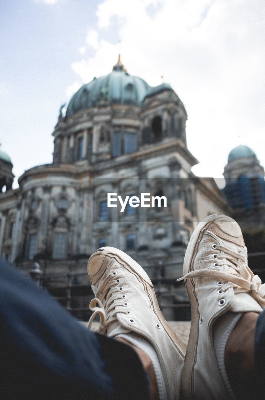 Low section of man wearing shoes against berlin cathedral