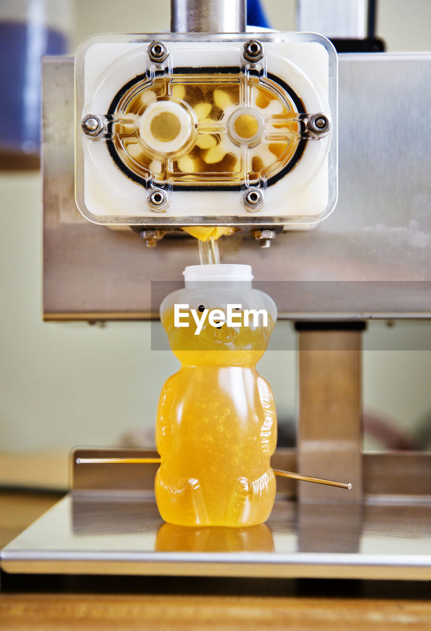 Honey being poured in bottle with machinery