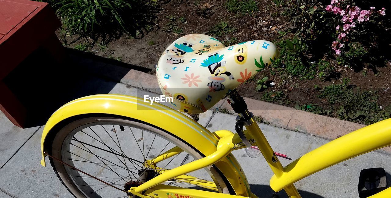 High angle view of yellow bicycle on footpath during sunny day