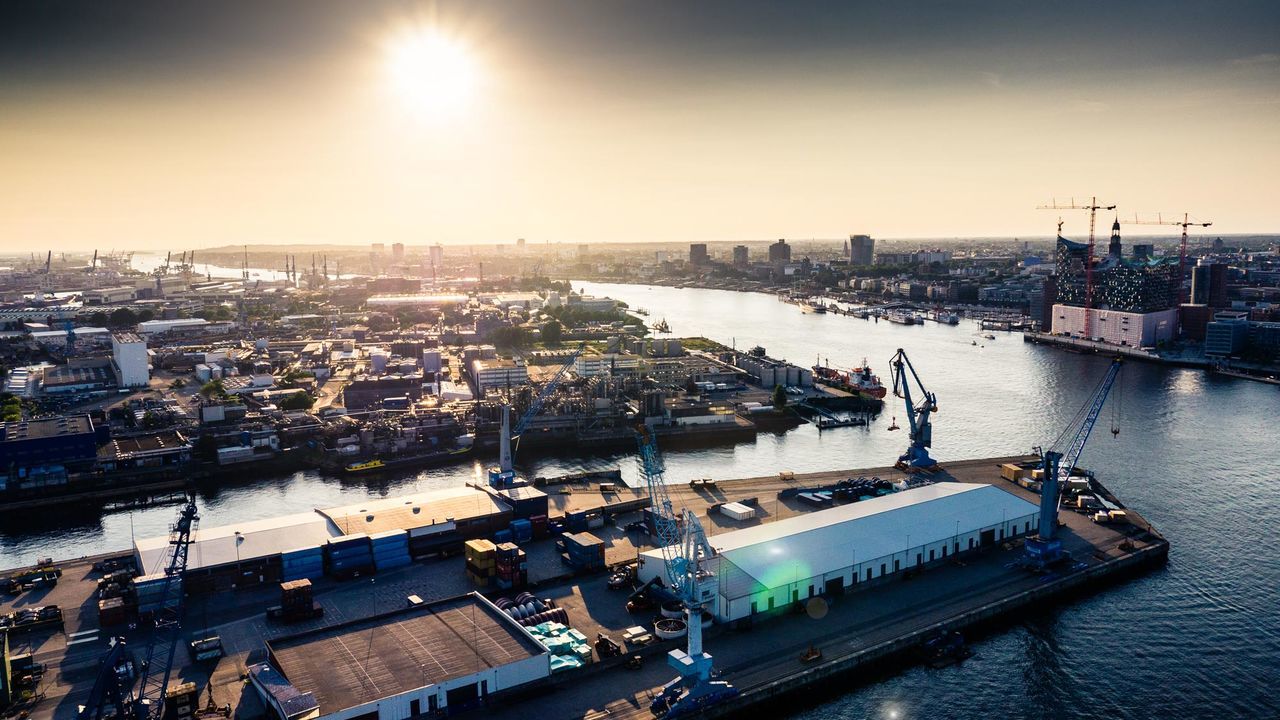 Port of hamburg by elbe river at sunset