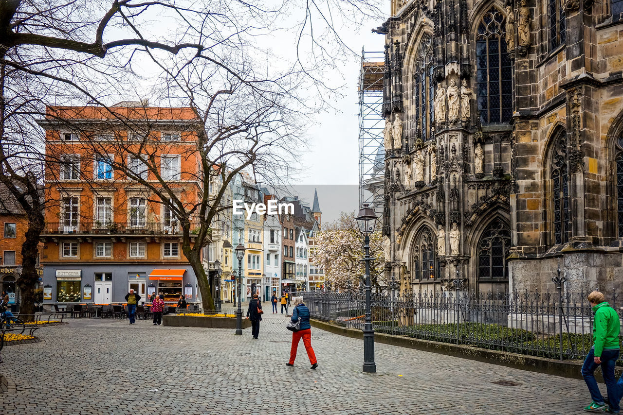 People walking on road along buildings