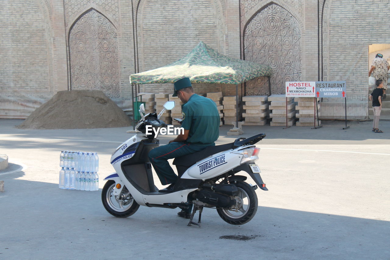 MAN RIDING MOTORCYCLE ON ROAD