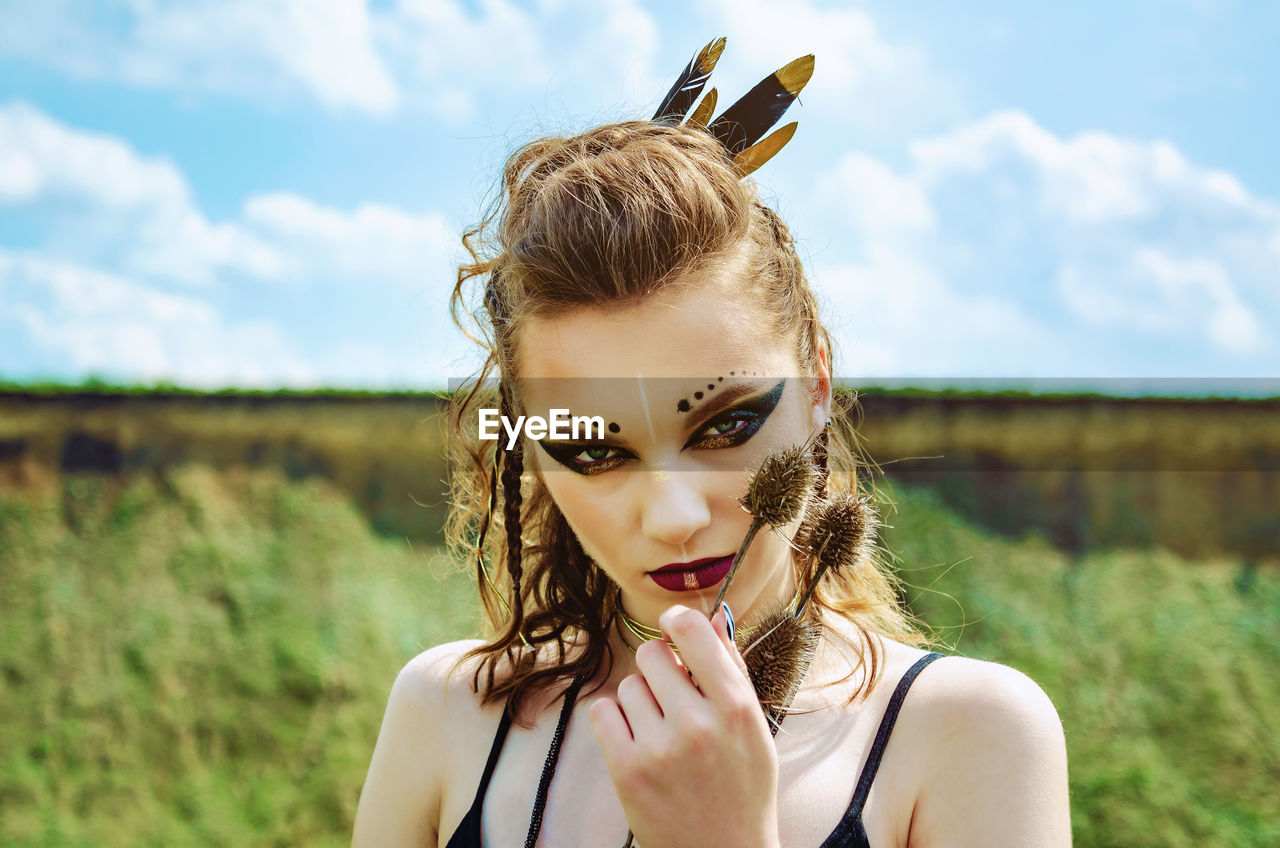 Portrait of beautiful woman with make-up against sky