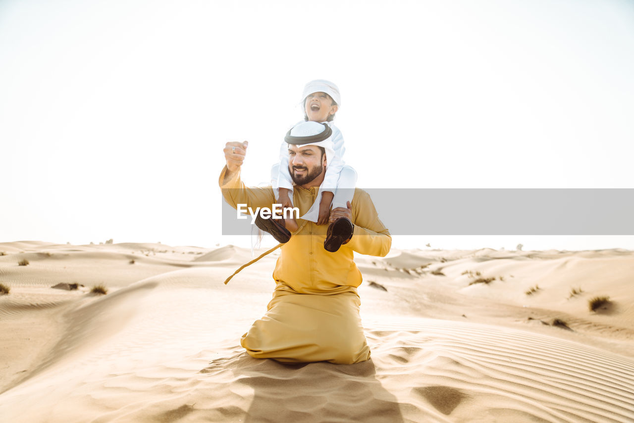 FULL LENGTH OF WOMAN STANDING ON SAND