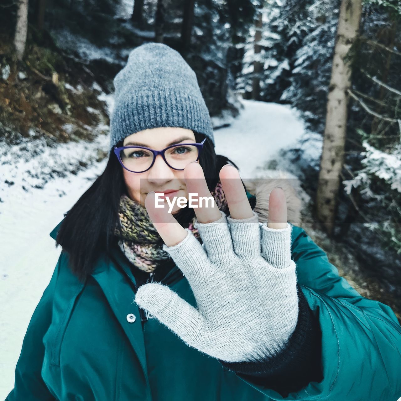 Portrait of young woman standing in snow