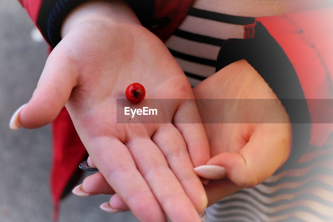 CLOSE-UP OF BABY HAND HOLDING A FRUIT