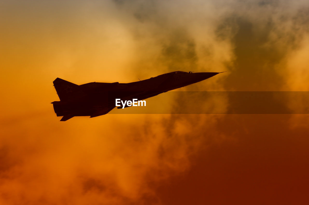 LOW ANGLE VIEW OF SILHOUETTE AIRPLANE AGAINST ORANGE SKY