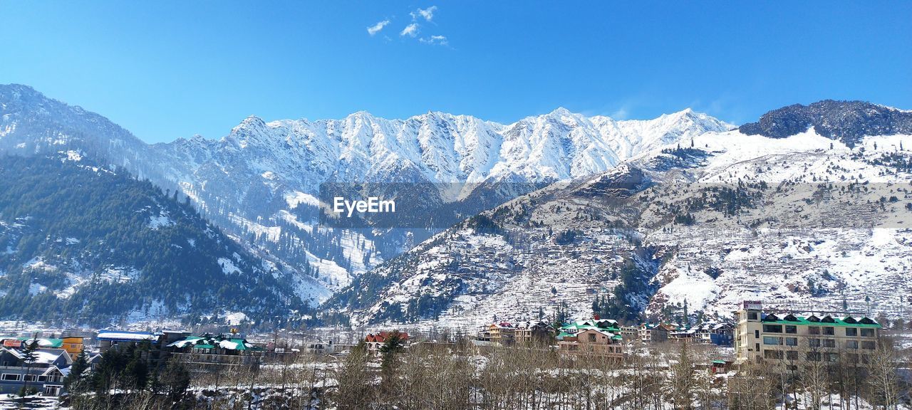 scenic view of snowcapped mountains against blue sky
