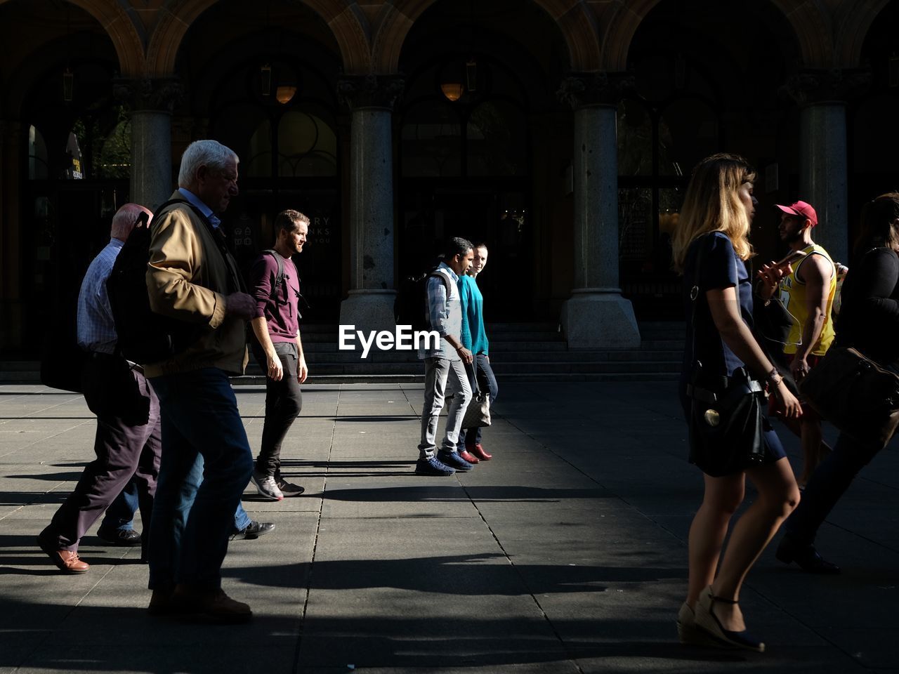 GROUP OF PEOPLE WALKING IN FRONT OF BUILDING