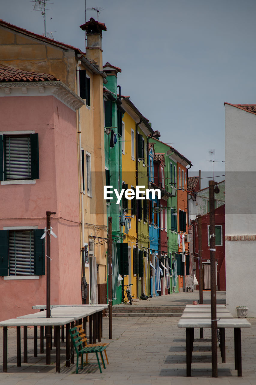 Houses by street in town against sky