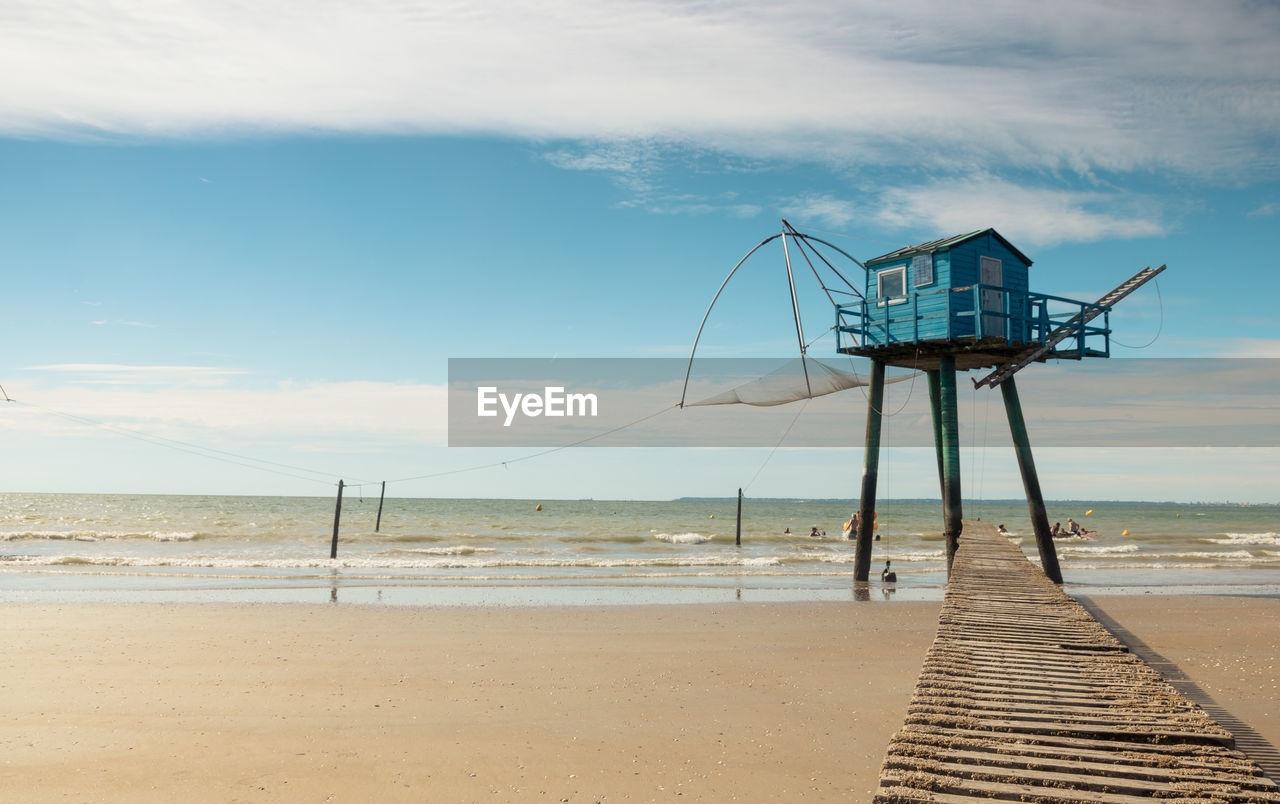 Blue fishing hut on beach in loire atlantique against sky