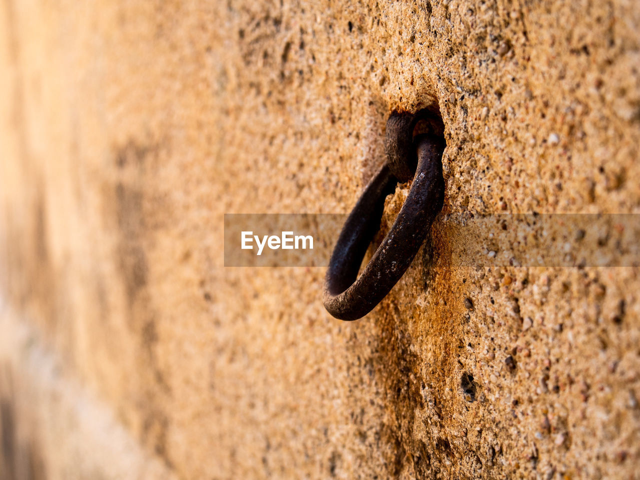 CLOSE-UP OF RUSTY METAL ON ROCK