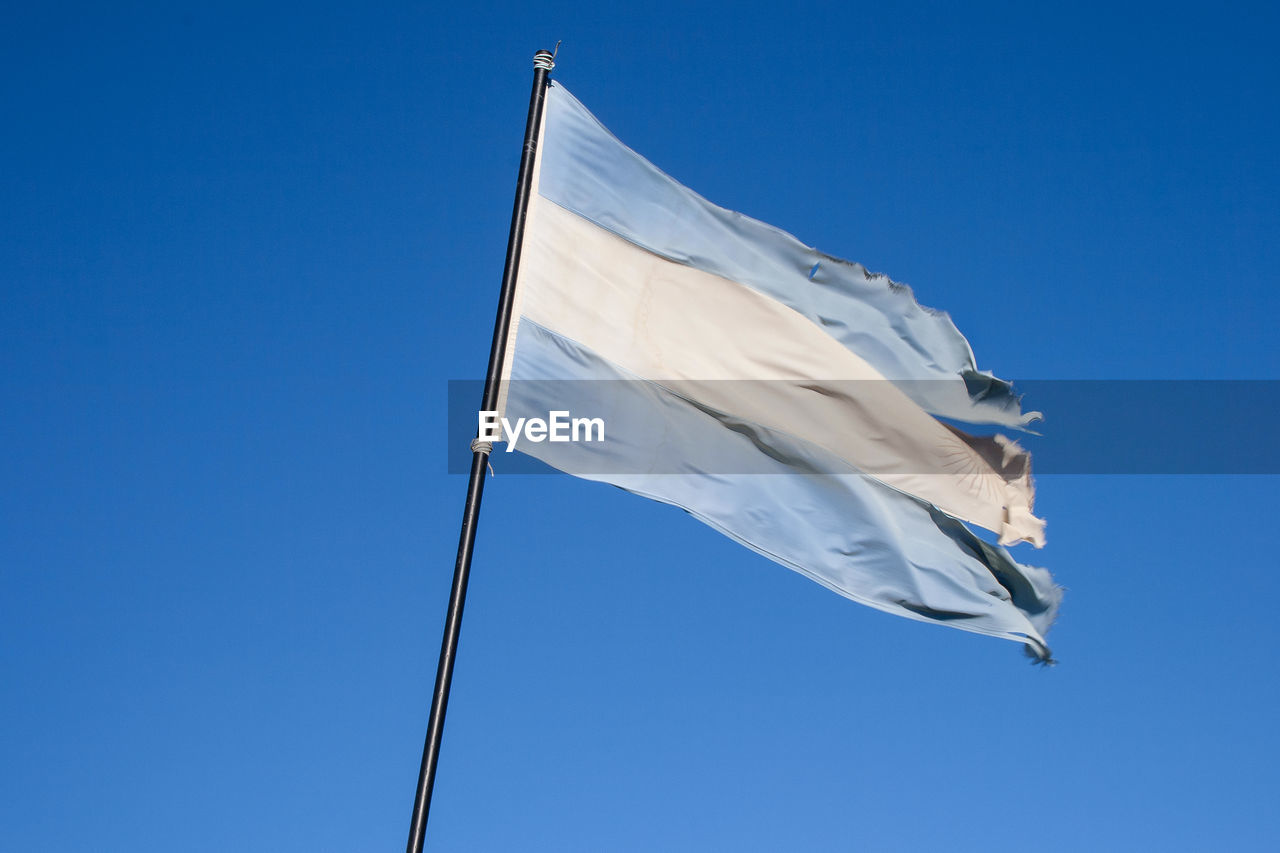 Low angle view of argentina flag against clear blue sky