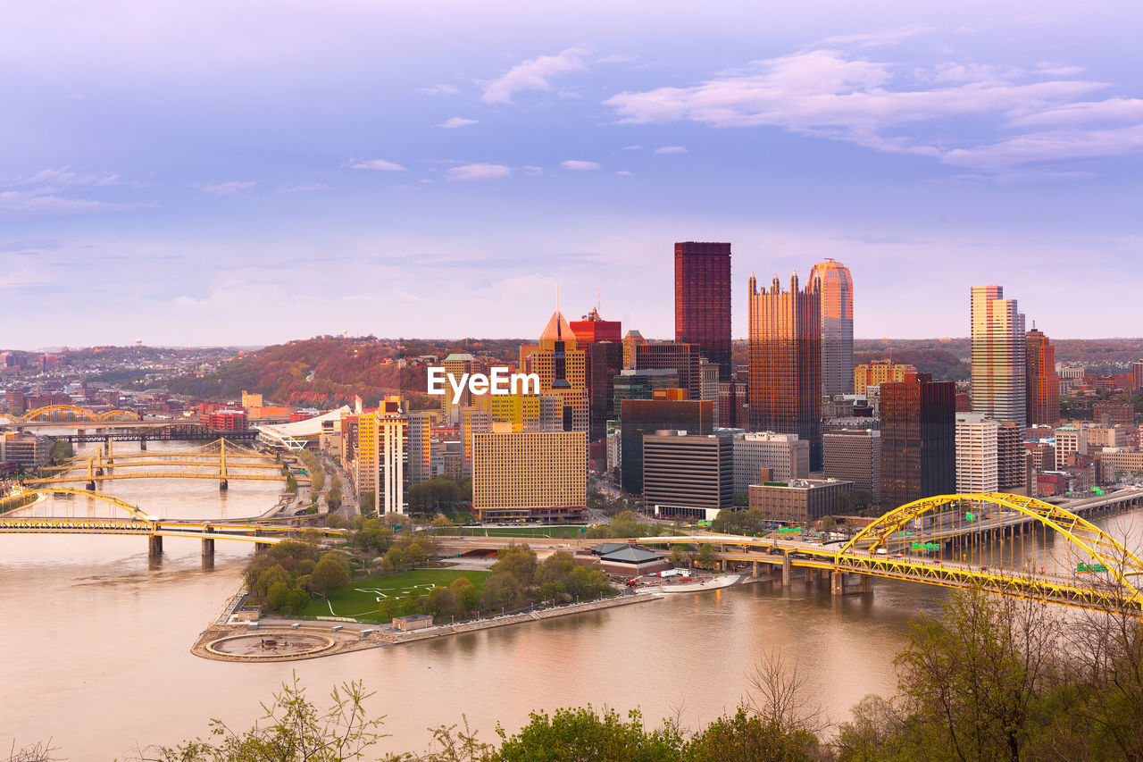 River by cityscape against sky