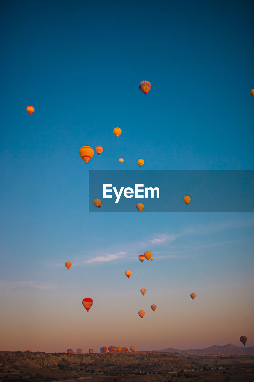 low angle view of balloons against clear sky during sunset