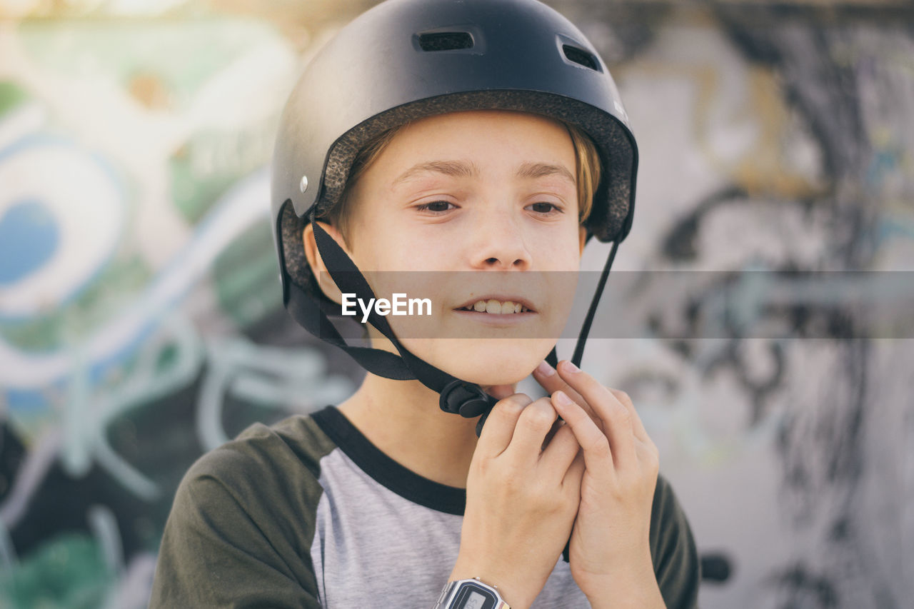 Close-up of boy wearing crash helmet outdoors