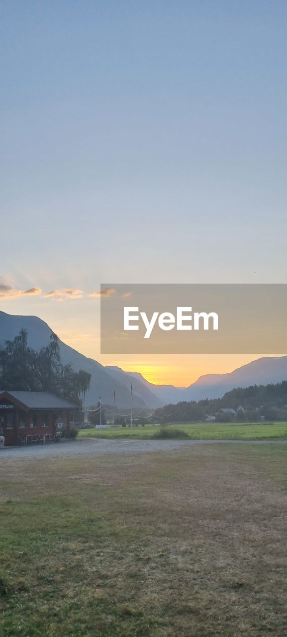 SCENIC VIEW OF FIELD AGAINST SKY AT SUNSET