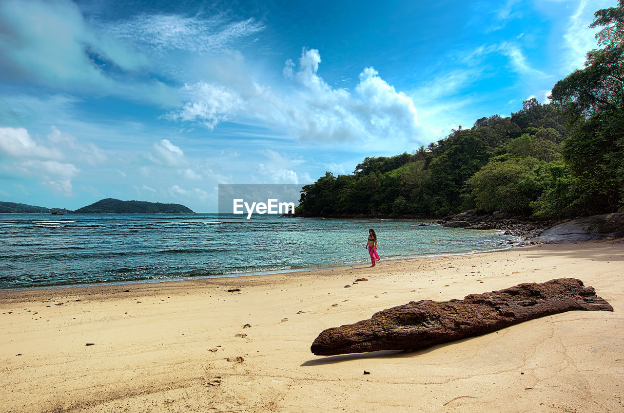 WOMAN ON BEACH AGAINST SKY