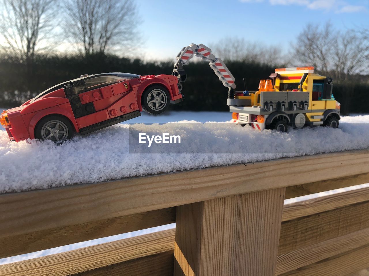 RED TOY CAR ON SNOW COVERED LANDSCAPE