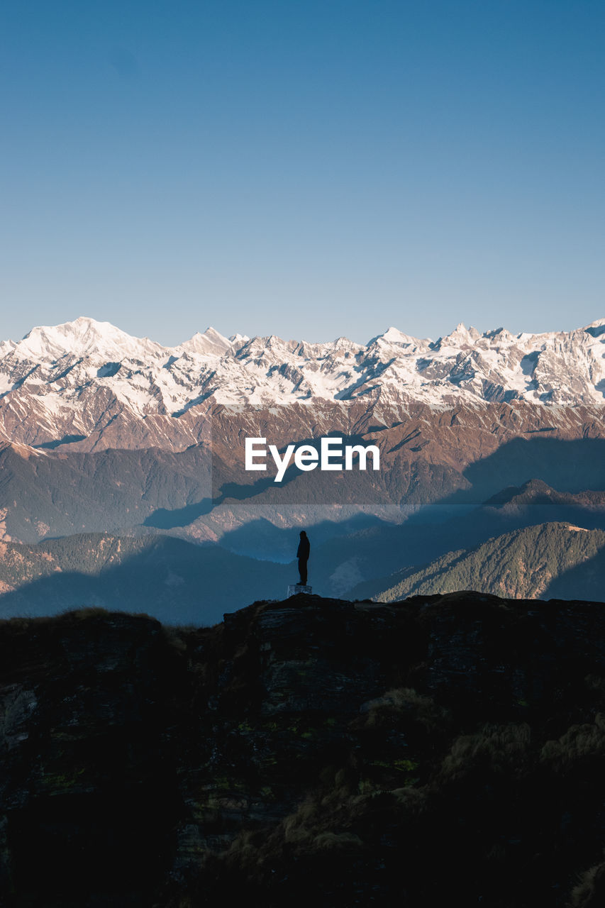 Scenic view of snowcapped mountains against blue sky