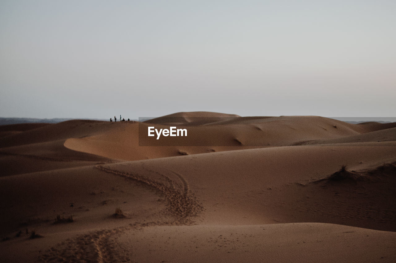 Sand dunes in desert against clear sky