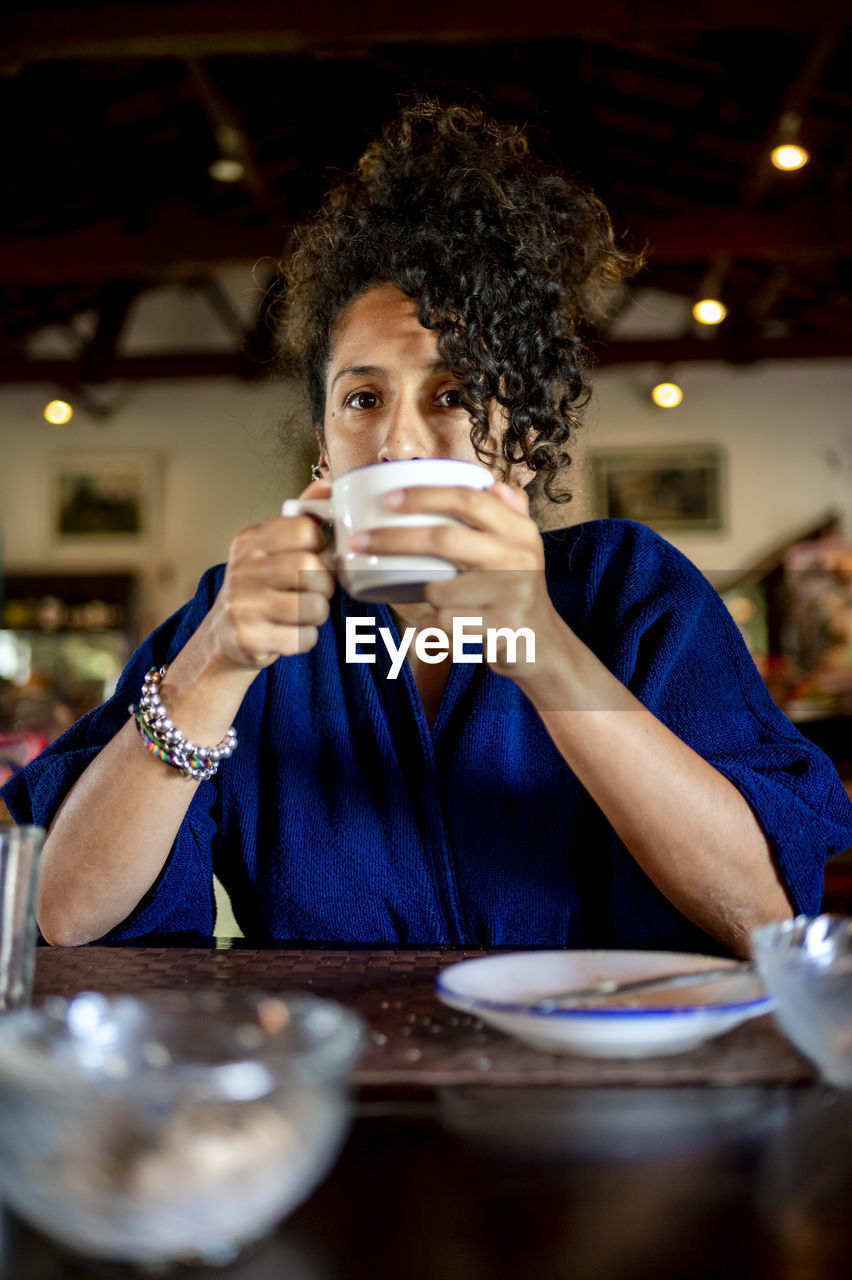 Relaxed woman smiling and drinking a cup of coffee