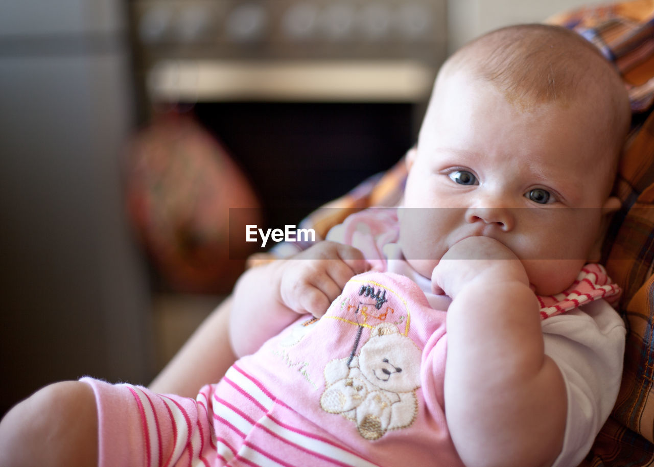 Portrait of cute baby in stroller at home