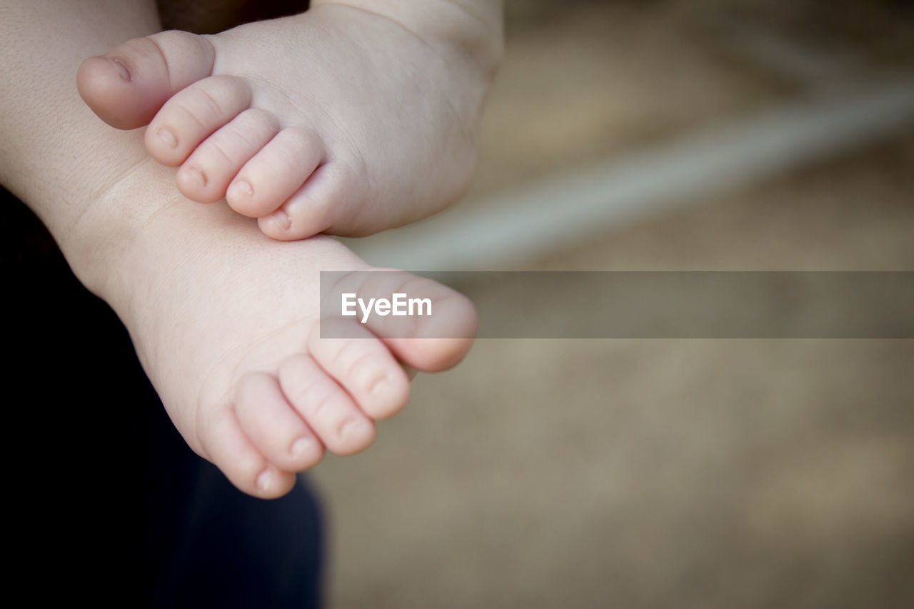 hand, close-up, child, baby, human leg, finger, limb, childhood, two people, adult, emotion, arm, togetherness, skin, love, men, indoors, human limb, bonding, family, female, holding hands, focus on foreground, human foot, care, toddler, women, person, positive emotion