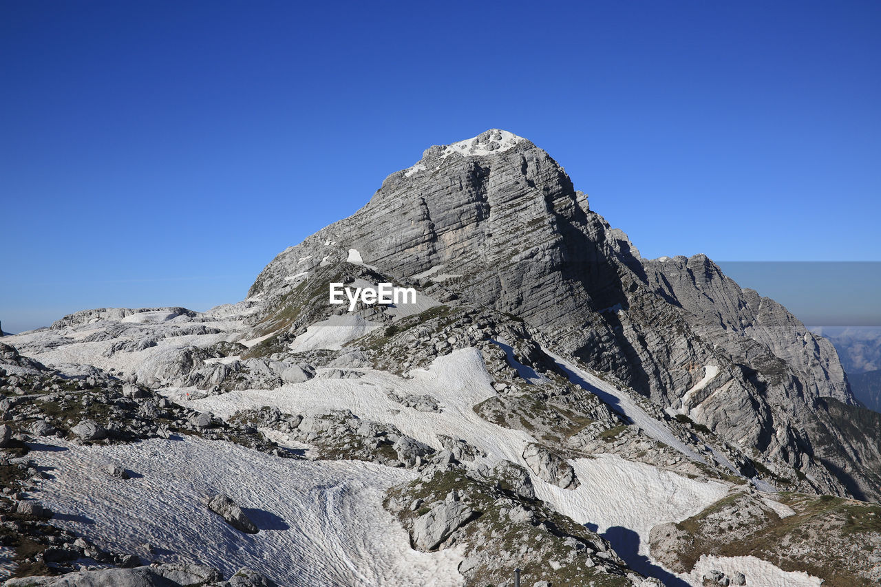 Low angle view of rock formation against clear blue sky. prehodavci, julian alps, slovenia