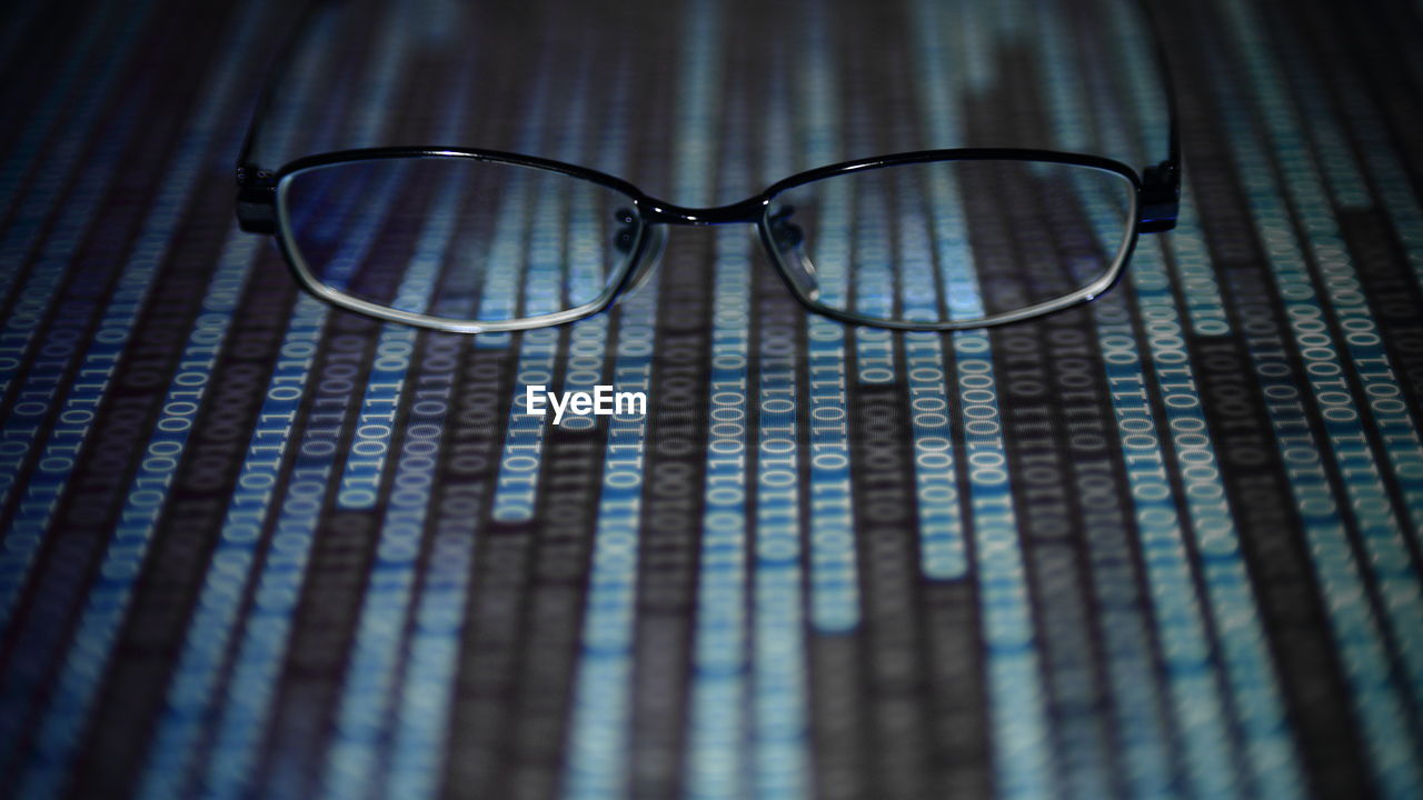 Close-up of eyeglasses on binary codes