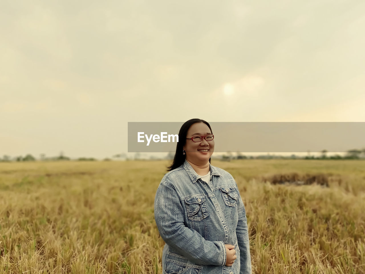 Portrait of smiling woman standing on land during sunset