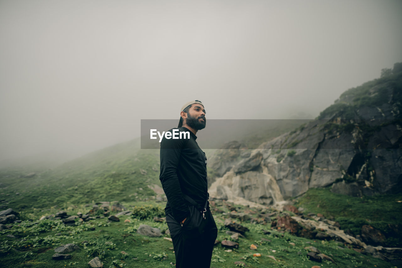 Rear view of man standing against mountain