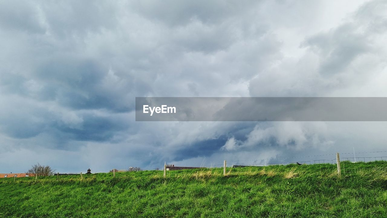 sky, cloud, environment, landscape, nature, plant, grass, land, storm, horizon, field, beauty in nature, storm cloud, rural scene, thunderstorm, plain, wind, grassland, scenics - nature, no people, outdoors, overcast, agriculture, green, prairie, rain, dramatic sky, cloudscape, day, rural area, wet, social issues, environmental conservation, hill