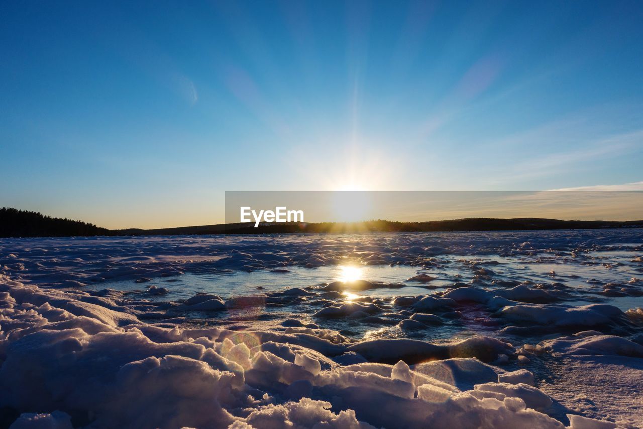 Scenic view of frozen sea against sky during sunset