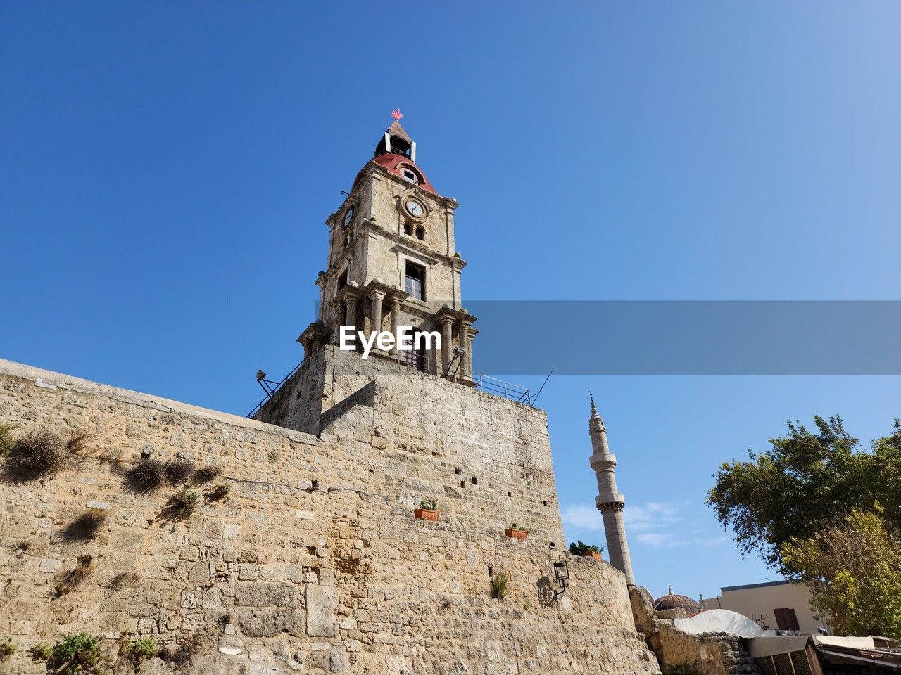 architecture, built structure, sky, building exterior, blue, clear sky, history, building, the past, nature, travel destinations, tower, religion, low angle view, place of worship, sunny, travel, belief, day, spirituality, tourism, outdoors, sunlight, fort, tree, no people, plant, bell tower, copy space, landmark, fortified wall, old, land