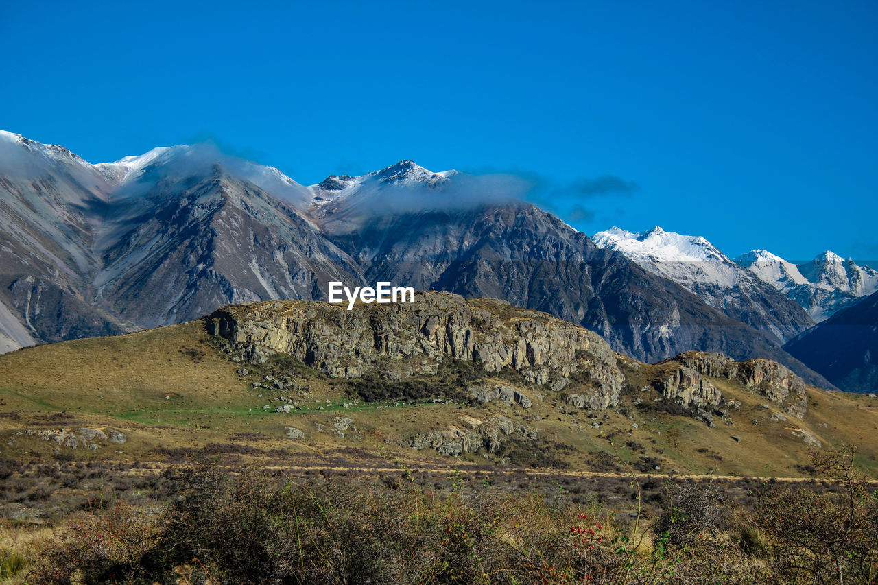 Scenic view of snowcapped mountains against blue sky