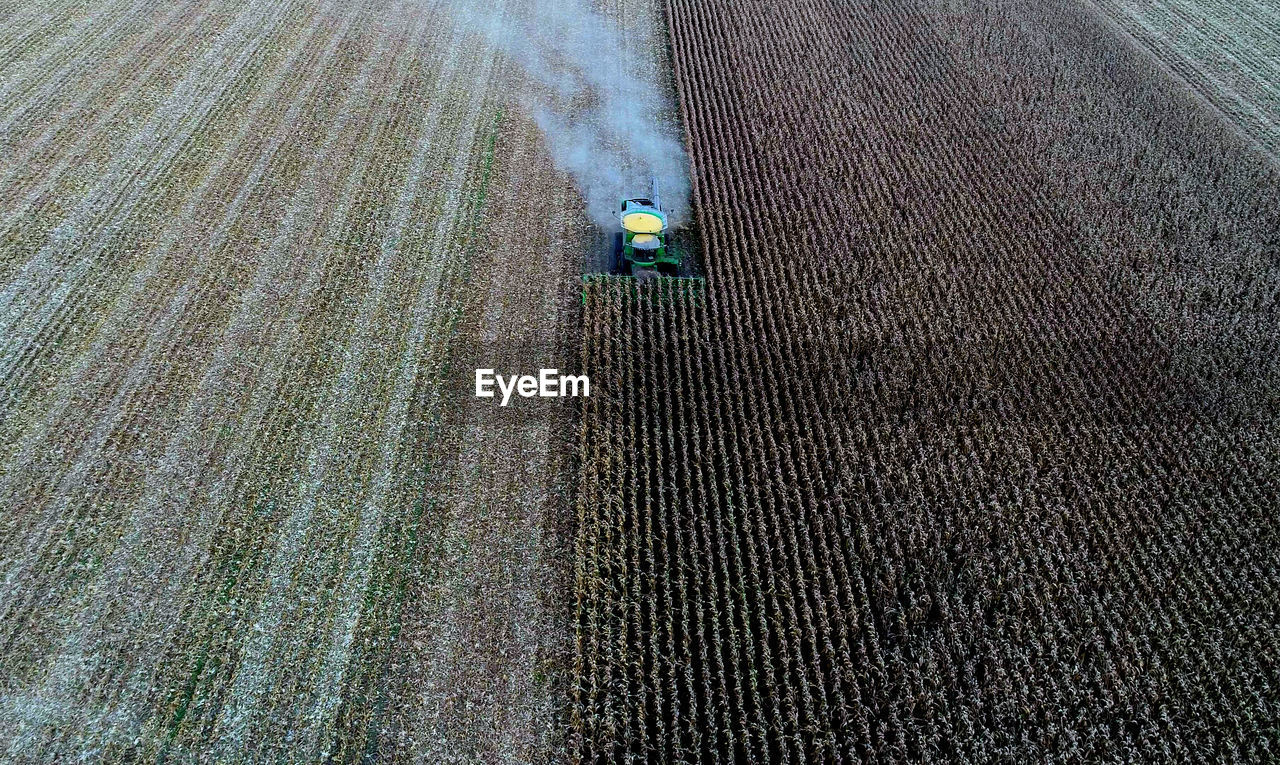 Aerial view of combine harvester harvesting crops at farm