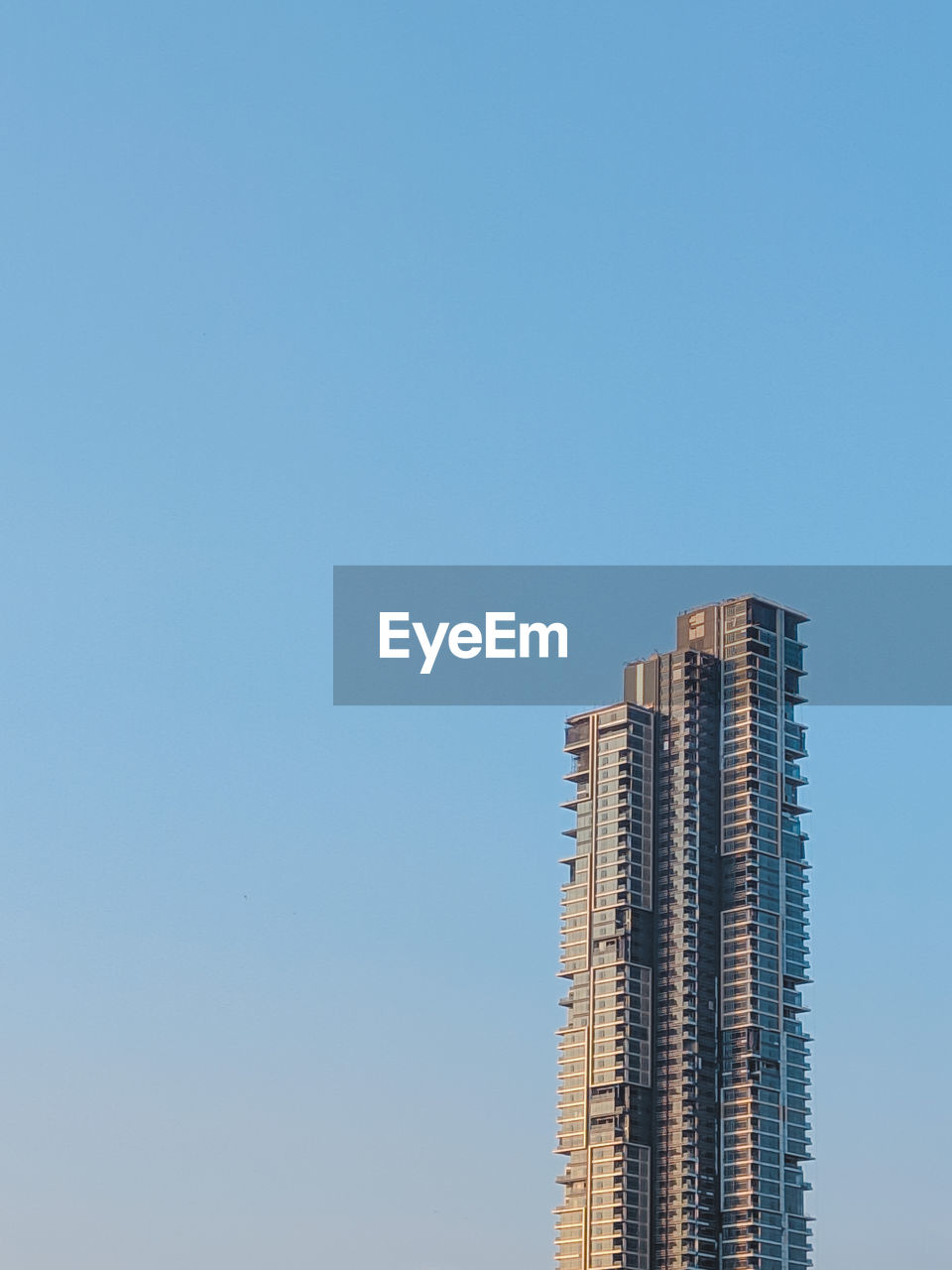 Low angle view of modern building against clear blue sky