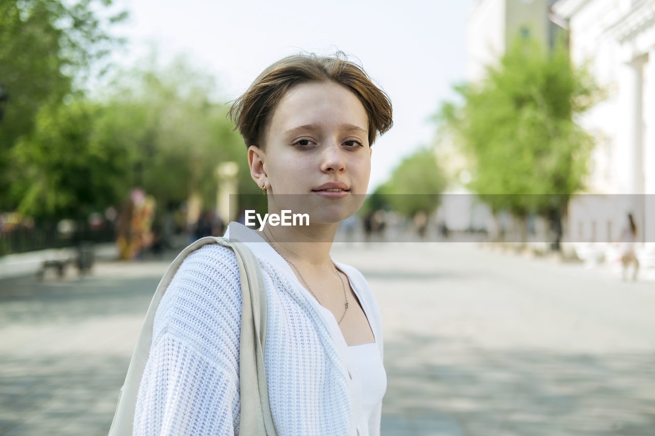 Street style meets youthful exuberance in the portrait of a teenage girl with bold red short hair