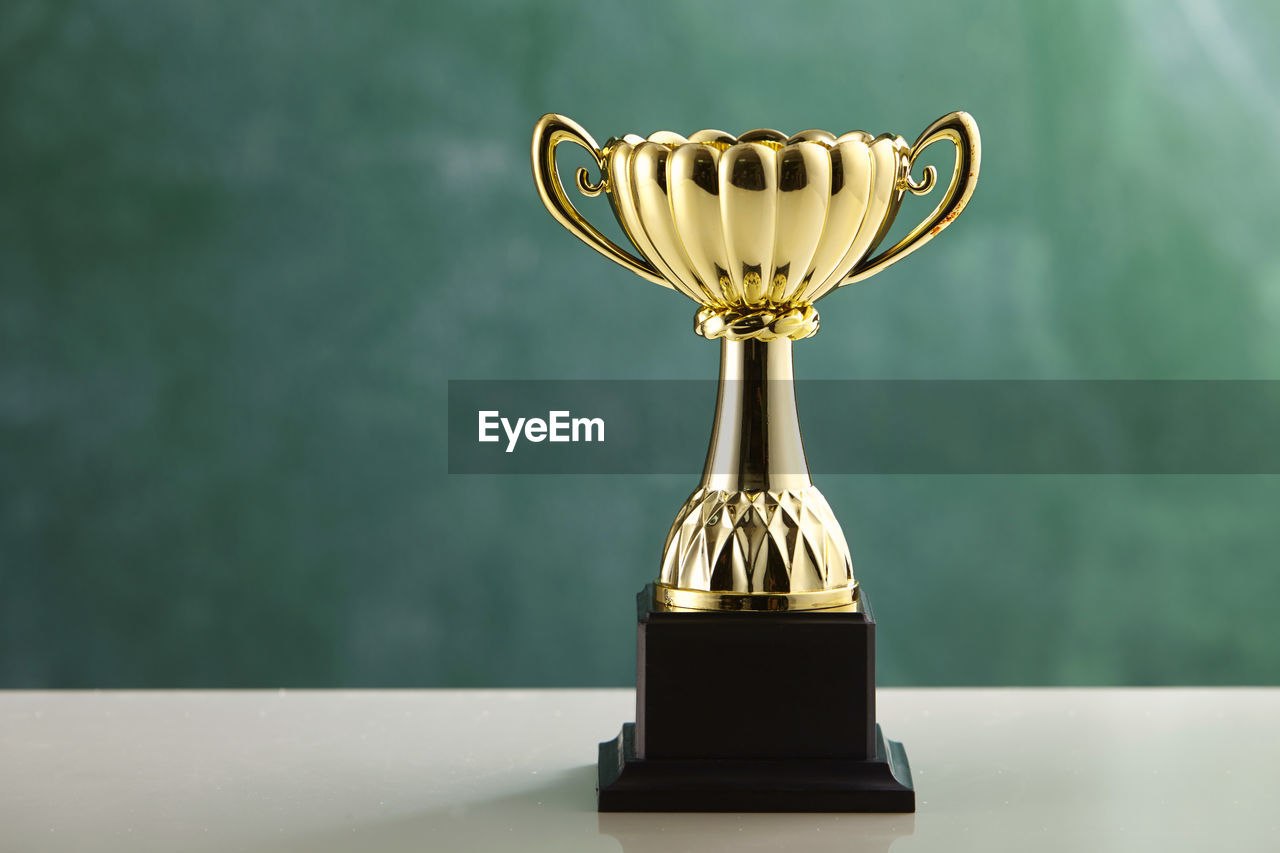 Trophy against blackboard on table