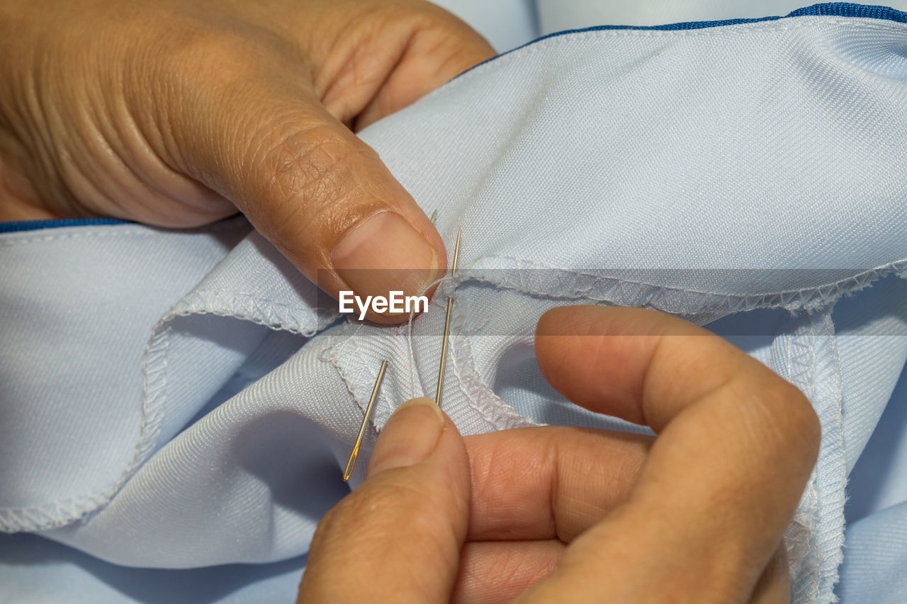 Midsection of tailor sewing textile