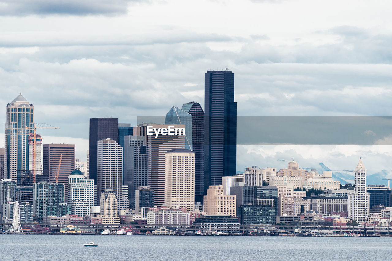 Buildings in city against cloudy sky