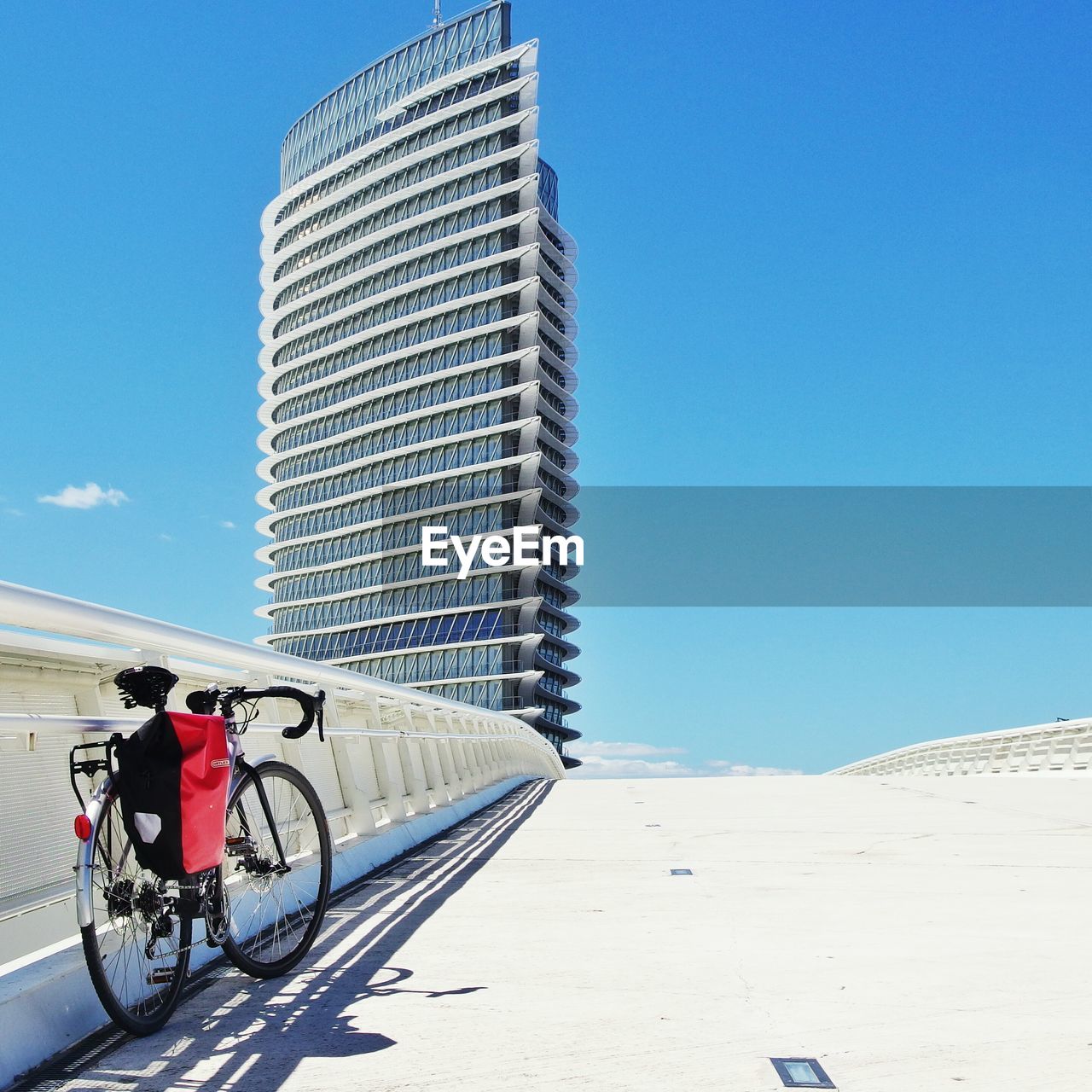 Bicycle parked on bridge with office building in background
