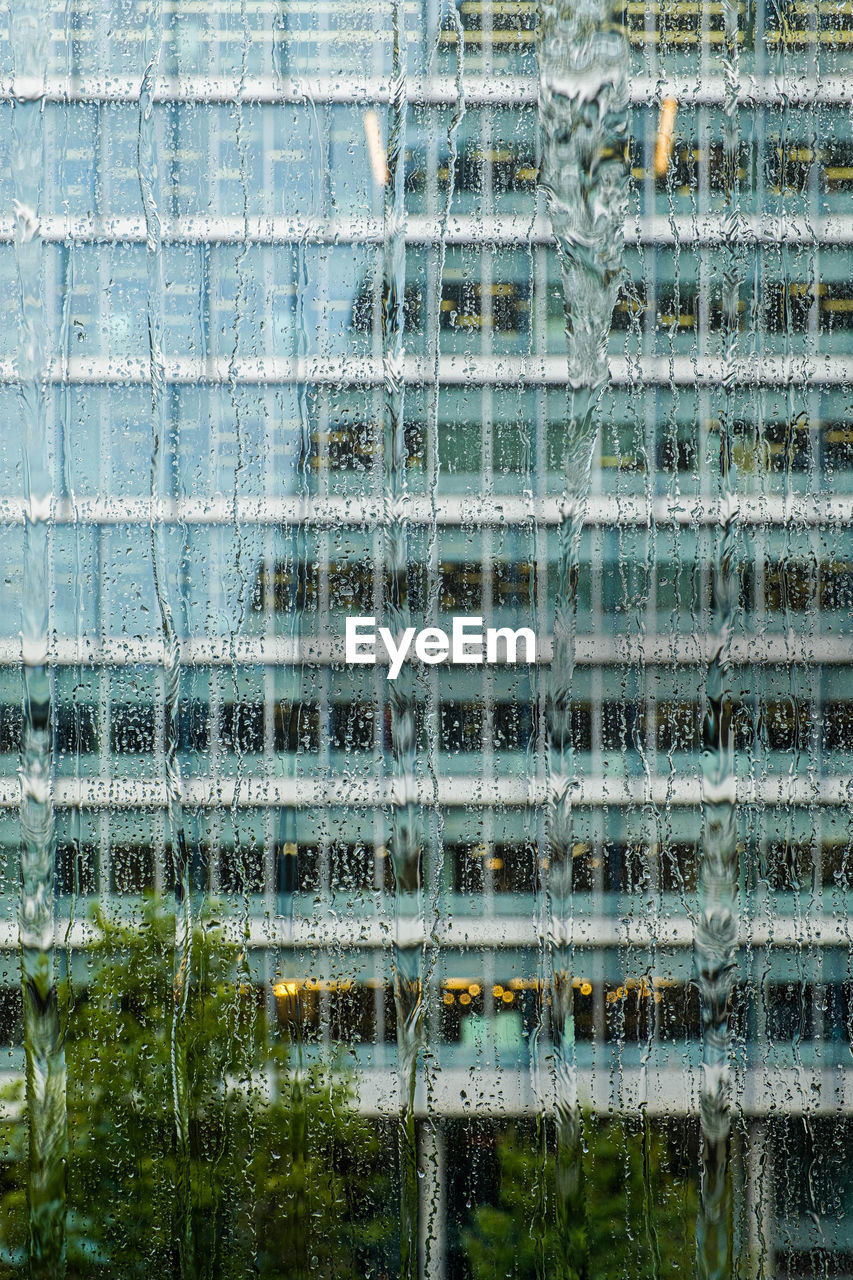 Building seen through wet window during rainy season