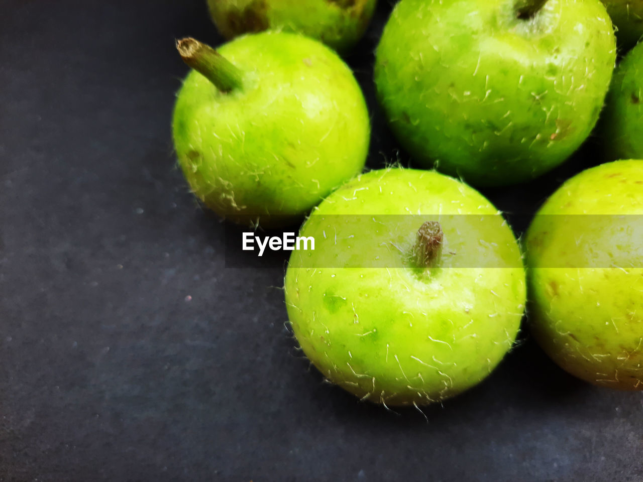 CLOSE-UP OF GREEN TOMATOES ON TABLE