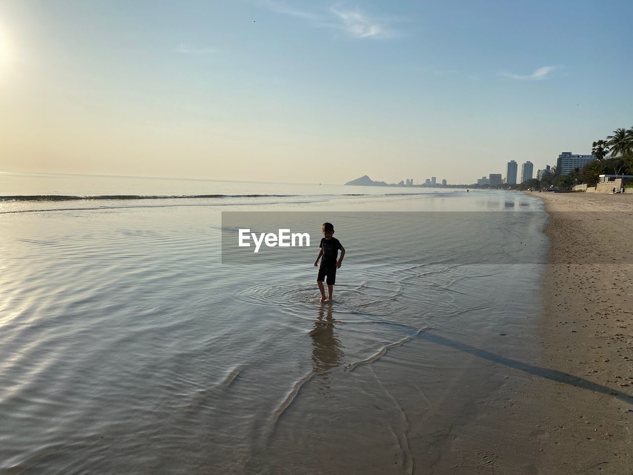 Child playing at sunrise at beach in early morning