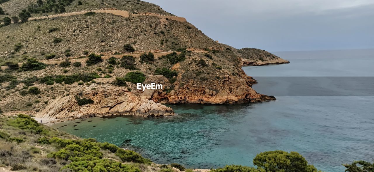 SCENIC VIEW OF ROCKS ON SHORE AGAINST SKY