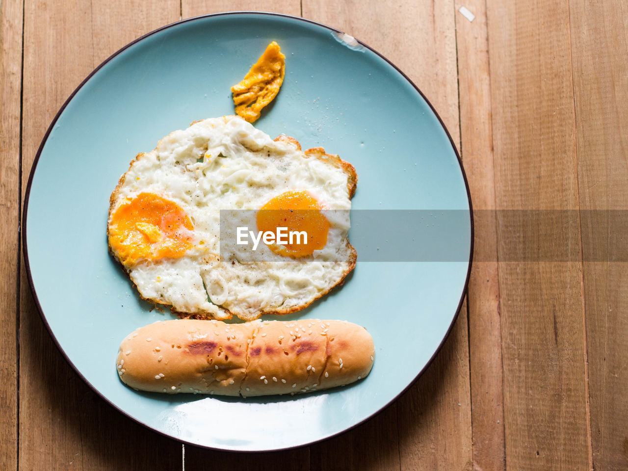 Breakfast skull fried eggs with vietnamese bread in dish on wood table