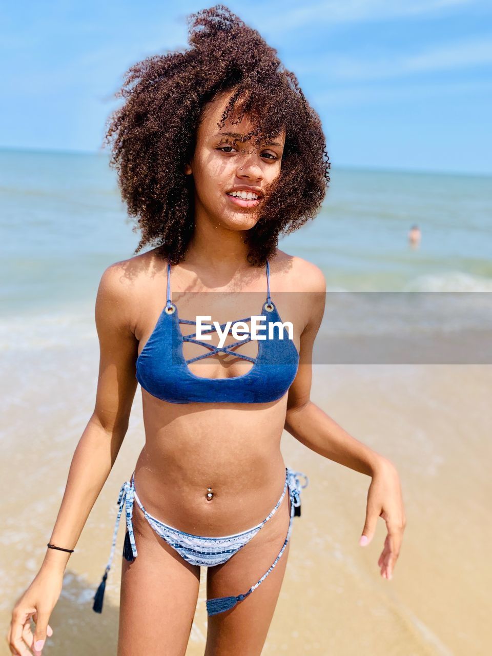 Portrait of woman in bikini standing at beach